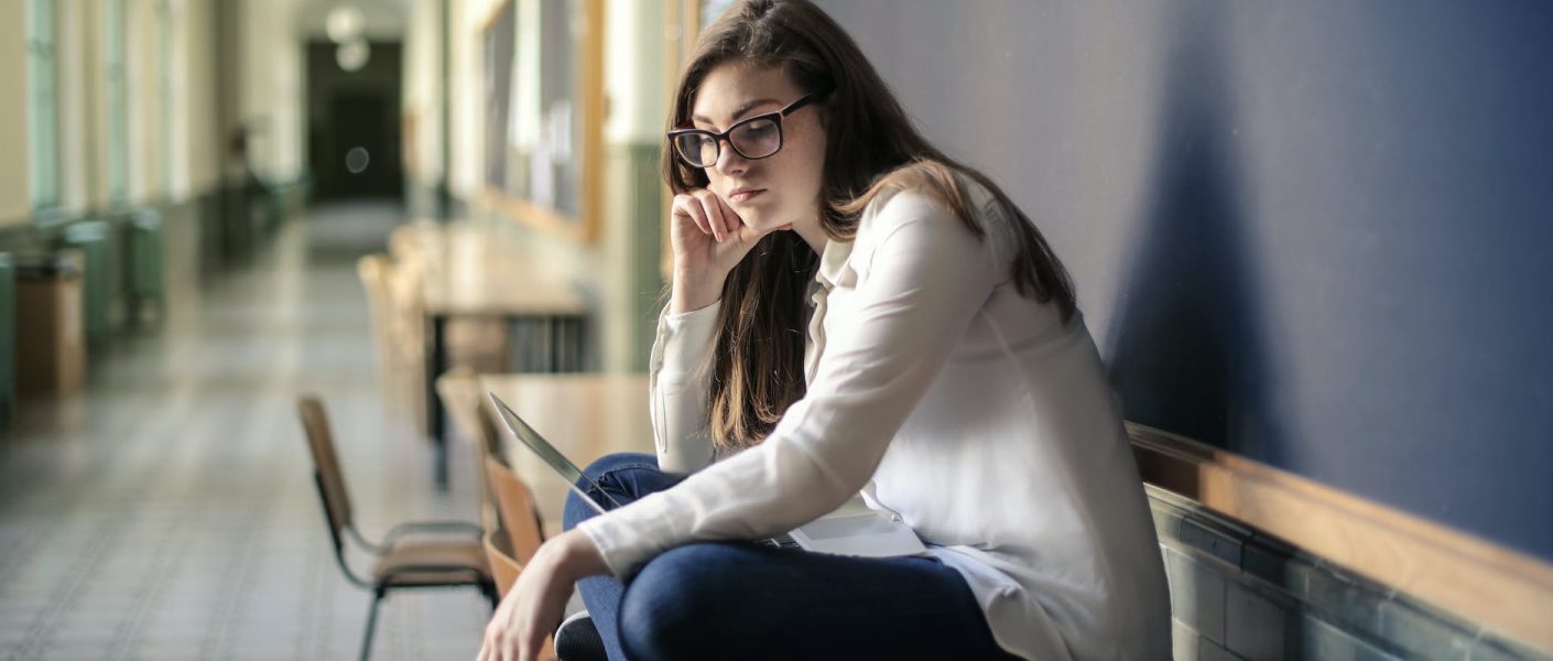 woman in white long sleeve shirt and blue denim jeans sitting on table